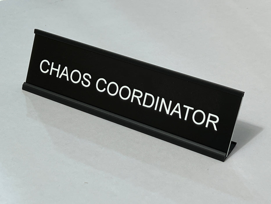 Funny desk sign with 'CHAOS COORDINATOR' text on a light gray background