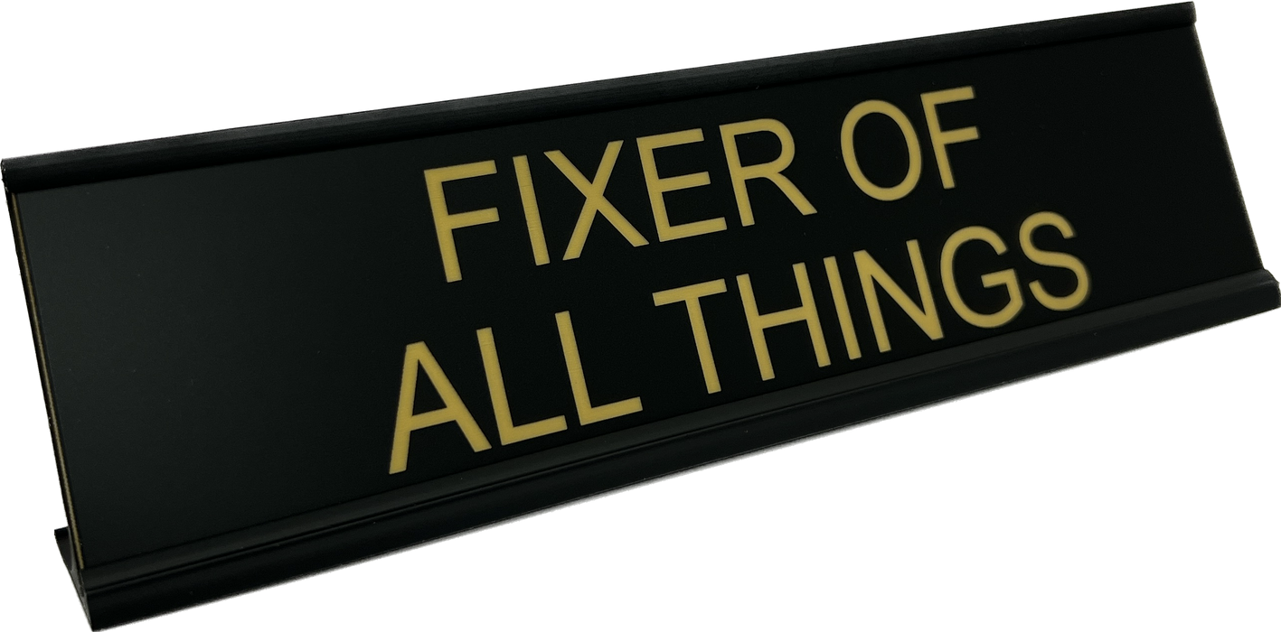 Fixer of all things desk sign show in in black with flat gold.
