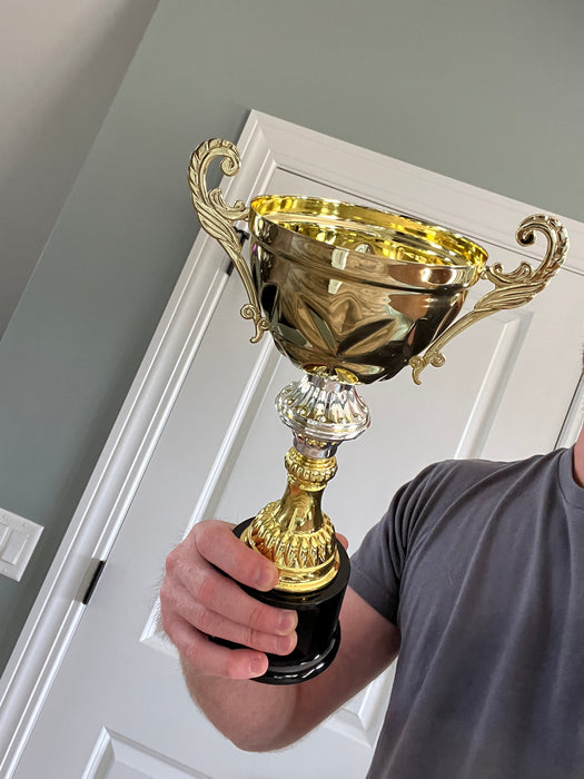 Lifestyle shot of gold trophy personalized with real metal cup trophy award.