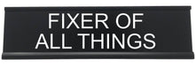 Funny office desk decor reads fixer of all things.