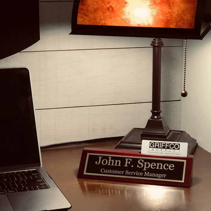 Custom desk name plate sitting under a lamp.